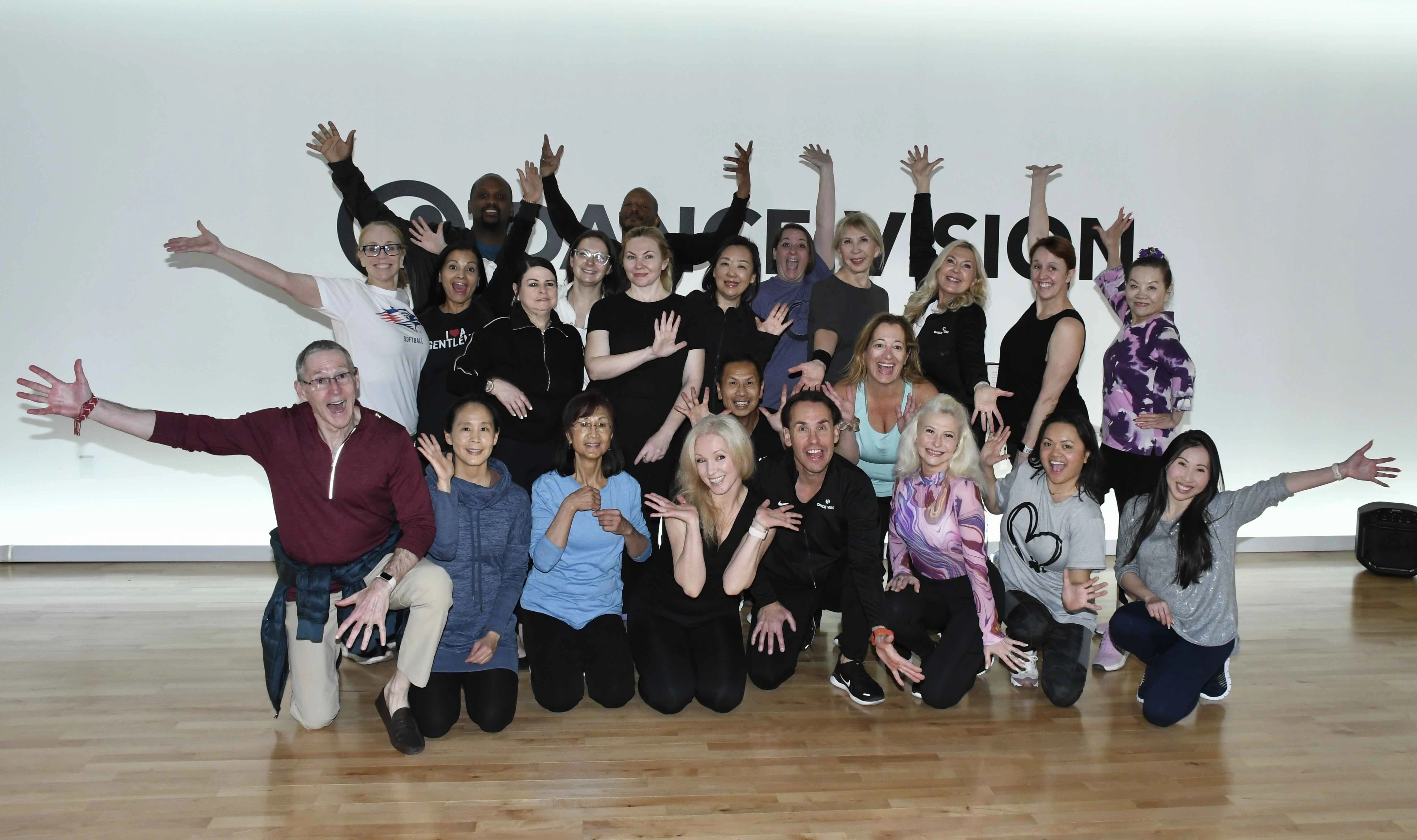 A group of people dancing enthusiastically in a dance studio